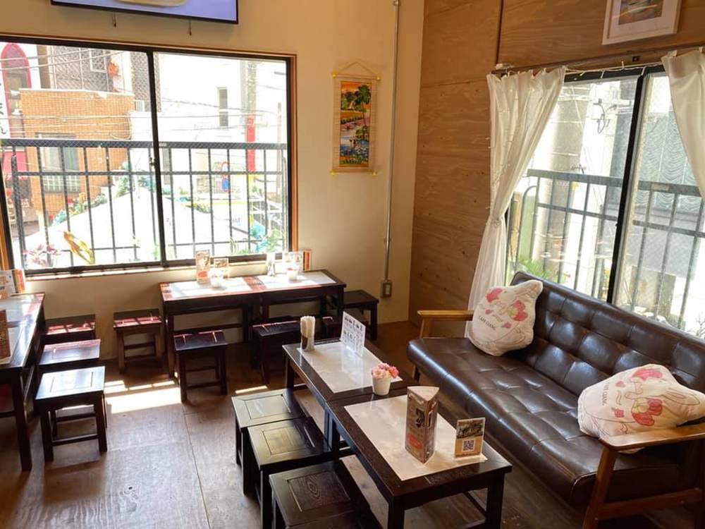 Qu&aacute;n c&agrave; ph&ecirc; nhỏ với b&agrave;n ghế gỗ, ghế sofa, &aacute;nh s&aacute;ng tự nhi&ecirc;n từ cửa sổ lớn, trang tr&iacute; đơn giản.