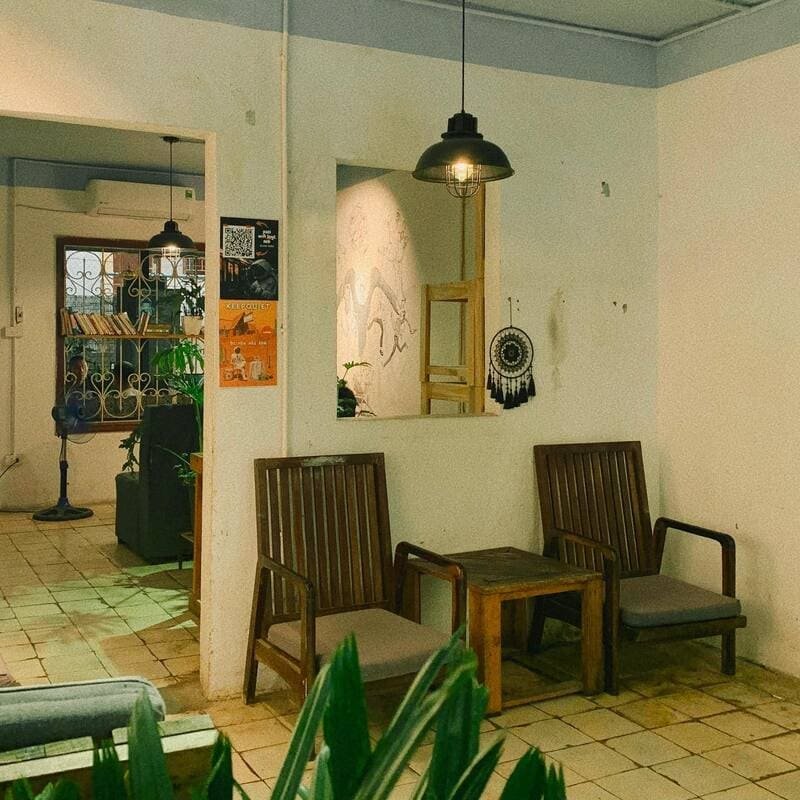 Quán cà phê phong cách vintage với nội thất gỗ ấm cúng, ánh sáng dịu nhẹ và cây trang trí xanh tươi.