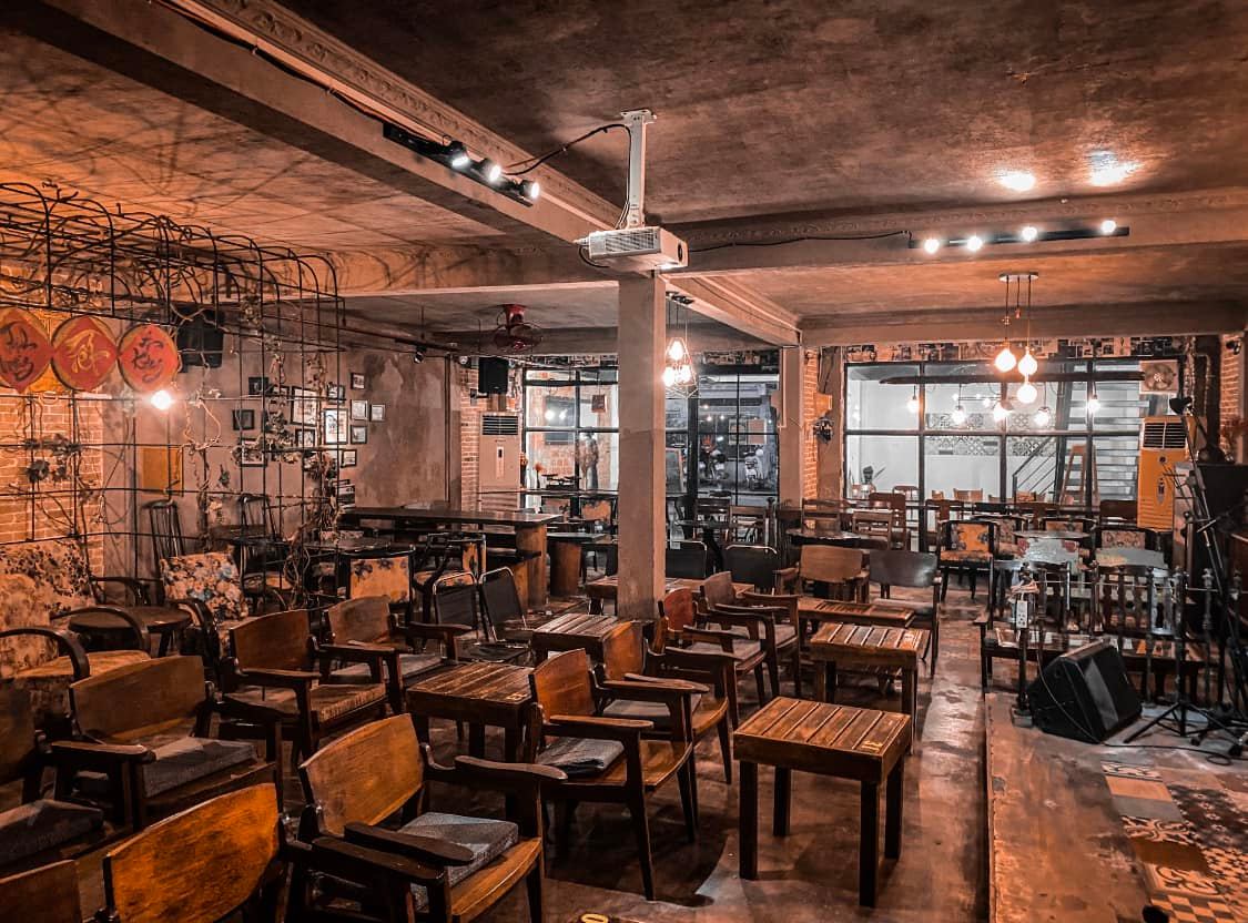 Kh&ocirc;ng gian qu&aacute;n c&agrave; ph&ecirc; với b&agrave;n ghế gỗ, &aacute;nh s&aacute;ng ấm &aacute;p v&agrave; trang tr&iacute; retro.