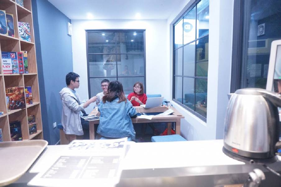 Nh&oacute;m người ngồi trong ph&ograve;ng s&aacute;ng, tr&ograve; chuyện v&agrave; l&agrave;m việc tr&ecirc;n m&aacute;y t&iacute;nh x&aacute;ch tay v&agrave; t&agrave;i liệu.