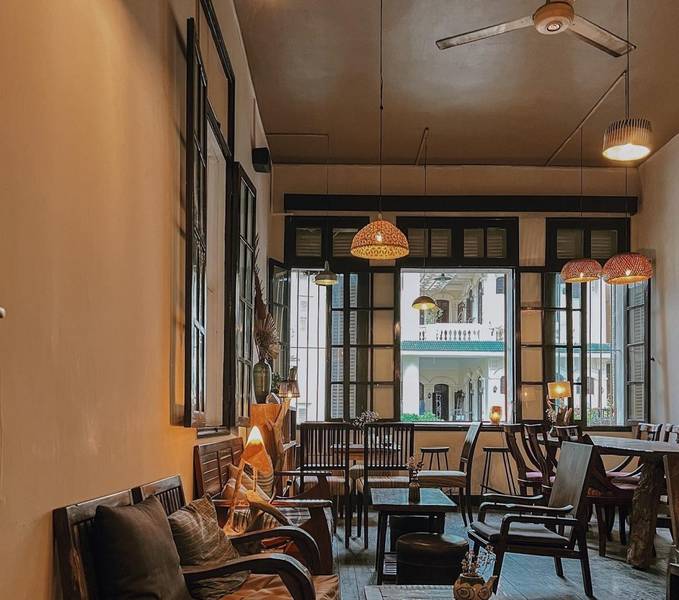 Qu&aacute;n c&agrave; ph&ecirc; phong c&aacute;ch cổ điển với trần cao, đ&egrave;n treo ấm c&uacute;ng v&agrave; cửa sổ lớn nh&igrave;n ra t&ograve;a nh&agrave; b&ecirc;n ngo&agrave;i.