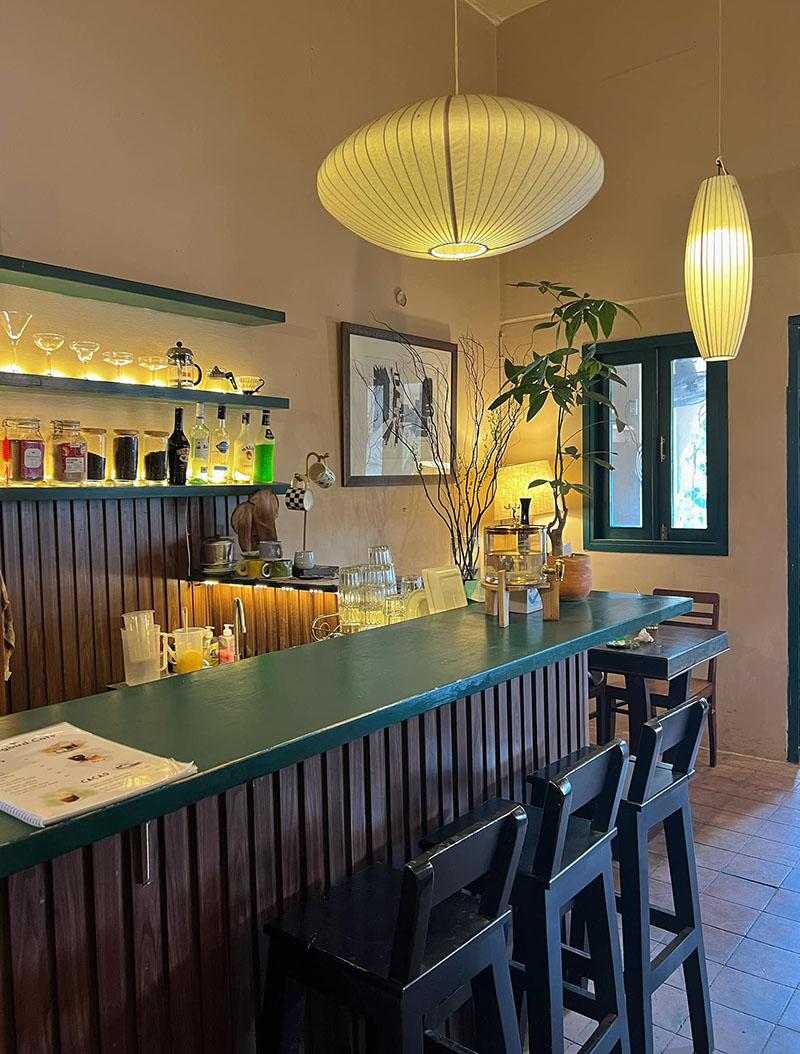 Quầy bar với ghế cao, đ&egrave;n treo v&agrave; kệ trưng b&agrave;y chai lọ, ly thủy tinh trong kh&ocirc;ng gian ấm c&uacute;ng v&agrave; trang tr&iacute; nhẹ nh&agrave;ng.