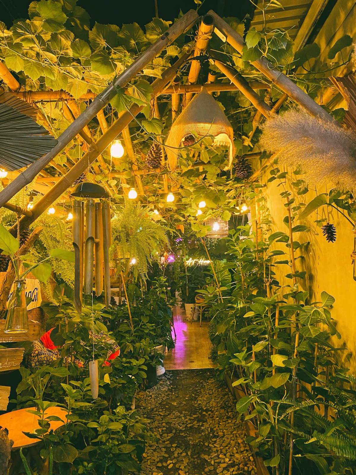 Lối đi nhỏ với cây xanh và ánh đèn vàng ấm áp, tạo không gian thư giãn và gần gũi với thiên nhiên.