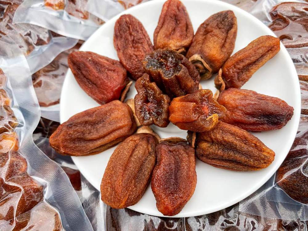 Đĩa hồng kh&ocirc; được sắp xếp tr&ecirc;n nền t&uacute;i nhựa, tạo th&agrave;nh v&ograve;ng tr&ograve;n đều đặn.