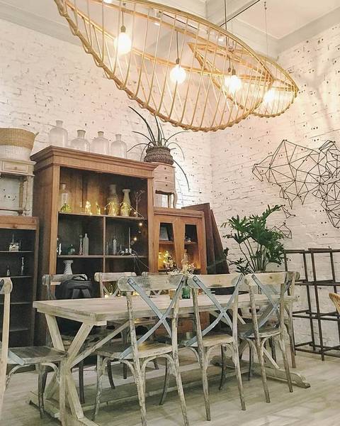 Ph&ograve;ng ăn phong c&aacute;ch mộc với b&agrave;n ghế gỗ, đ&egrave;n treo h&igrave;nh thuyền, tường gạch trắng v&agrave; kệ trang tr&iacute;.