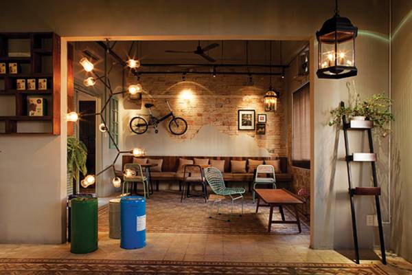 Quán cà phê với thiết kế ấm cúng, trang trí bằng xe đạp treo tường, đèn treo và nội thất gỗ.