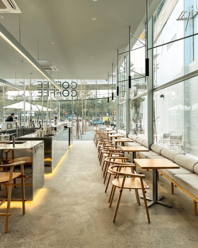 Qu&aacute;n c&agrave; ph&ecirc; hiện đại với b&agrave;n ghế gỗ, &aacute;nh s&aacute;ng tự nhi&ecirc;n từ cửa k&iacute;nh lớn, kh&ocirc;ng gian tho&aacute;ng đ&atilde;ng.