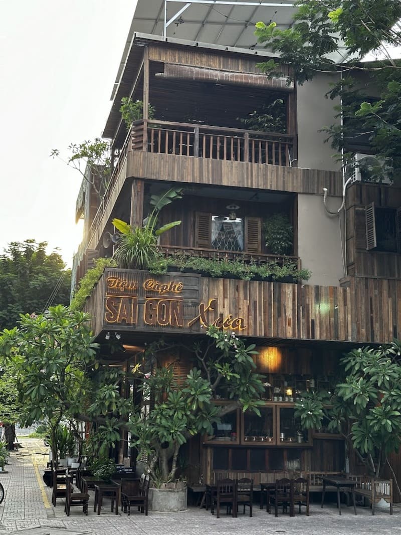 Qu&aacute;n c&agrave; ph&ecirc; hai tầng với thiết kế gỗ, c&acirc;y xanh bao quanh, bảng hiệu "S&agrave;i G&ograve;n Xưa" ph&iacute;a trước.