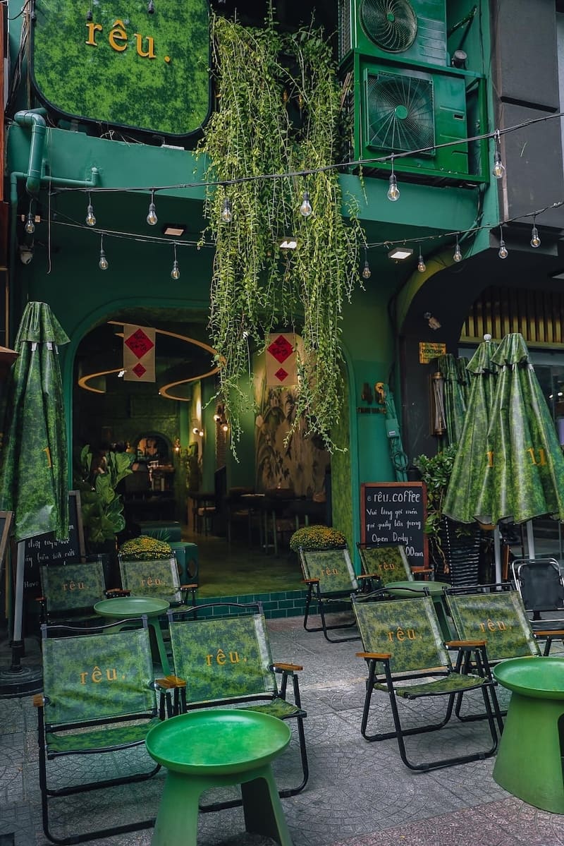 Qu&aacute;n c&agrave; ph&ecirc; với thiết kế m&agrave;u xanh l&aacute;, ghế ngồi ngo&agrave;i trời v&agrave; c&acirc;y leo trang tr&iacute; tạo kh&ocirc;ng gian tho&aacute;ng đ&atilde;ng.