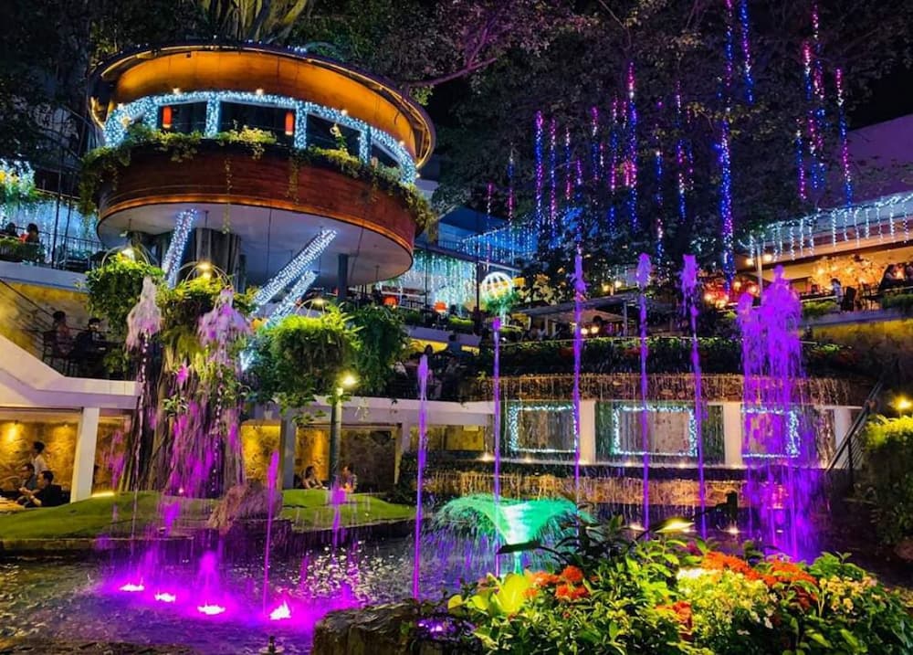 Khám Phá Du Miên Garden Cafe: Địa Điểm Độc Đáo Ngắm Sài Gòn Từ Trên Cao 6 Quán cà phê ban đêm với đèn trang trí rực rỡ, thác nước và cây xanh tạo không gian lung linh.
