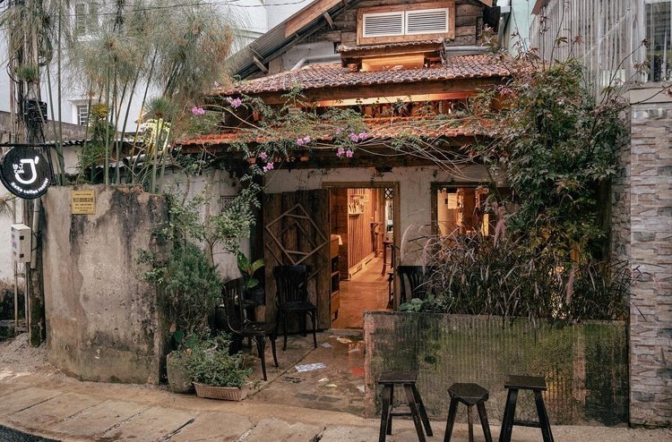 Qu&aacute;n c&agrave; ph&ecirc; nhỏ xinh với m&aacute;i ng&oacute;i đỏ, c&acirc;y xanh bao quanh, kh&ocirc;ng gian ấm c&uacute;ng v&agrave; mộc mạc ở th&agrave;nh phố.