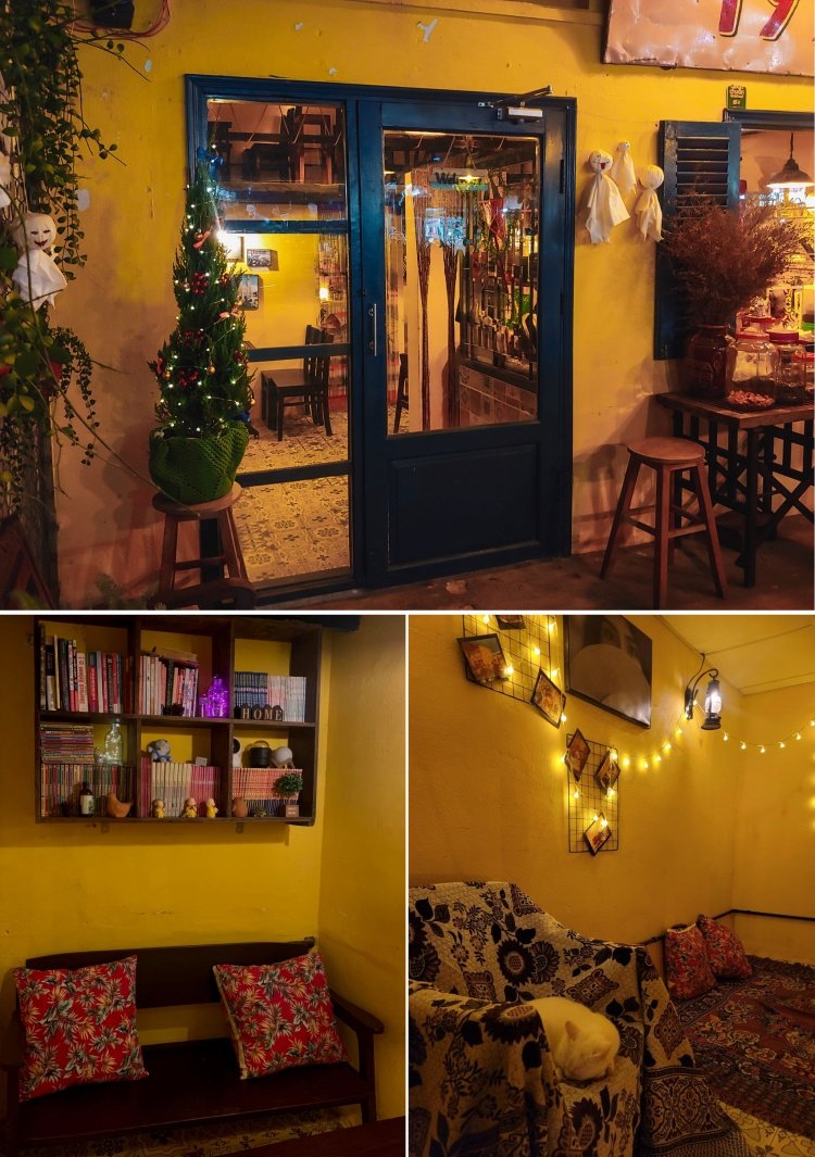 Qu&aacute;n c&agrave; ph&ecirc; ấm c&uacute;ng với cửa k&iacute;nh, đ&egrave;n trang tr&iacute;, c&acirc;y th&ocirc;ng Noel v&agrave; kệ s&aacute;ch c&ugrave;ng ghế sofa thoải m&aacute;i.