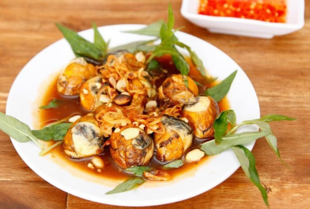 Khám Phá Cafe Bờ Kè Nóc Hầm Thủ Thiêm: Địa Điểm Thư Giãn và Ngắm Cảnh Tuyệt Vời 6 Đĩa trứng lộn xào me với rau răm, hành phi và đậu phộng, bên cạnh là chén nước chấm.