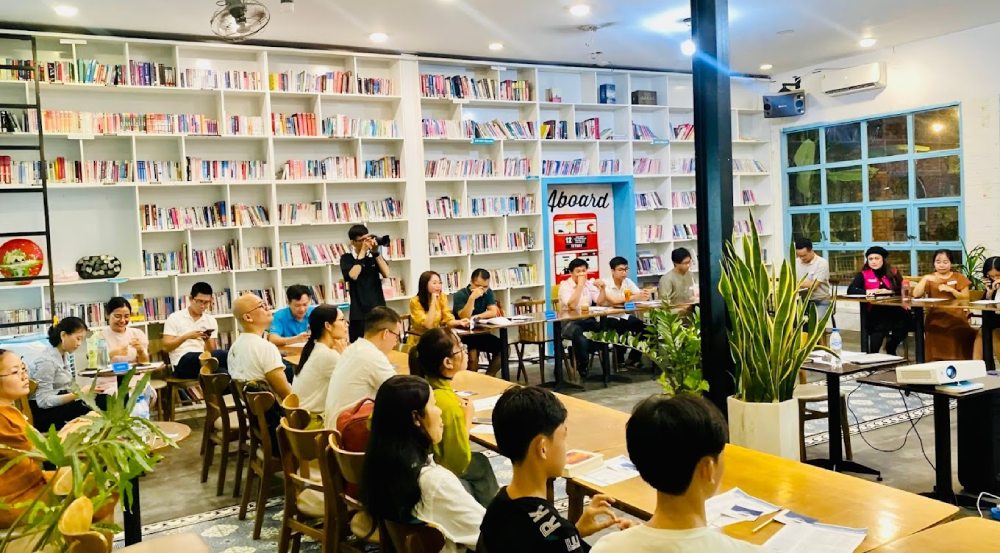 Top 11+ Quán Cafe Đẹp Tại Đà Nẵng Không Thể Bỏ Qua Năm 2025 10 Nhóm người ngồi trong một thư viện hiện đại, tham gia buổi họp hoặc hội thảo.