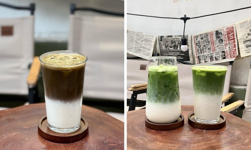 Khám Phá Top Quán Cafe Hấp Dẫn Trên Đường Nguyễn Chí Thanh - Điểm Đến Thú Vị 15 Ba ly đồ uống với lớp trên màu nâu và xanh lá, đặt trên bàn gỗ, nền là ghế và báo treo trên tường.