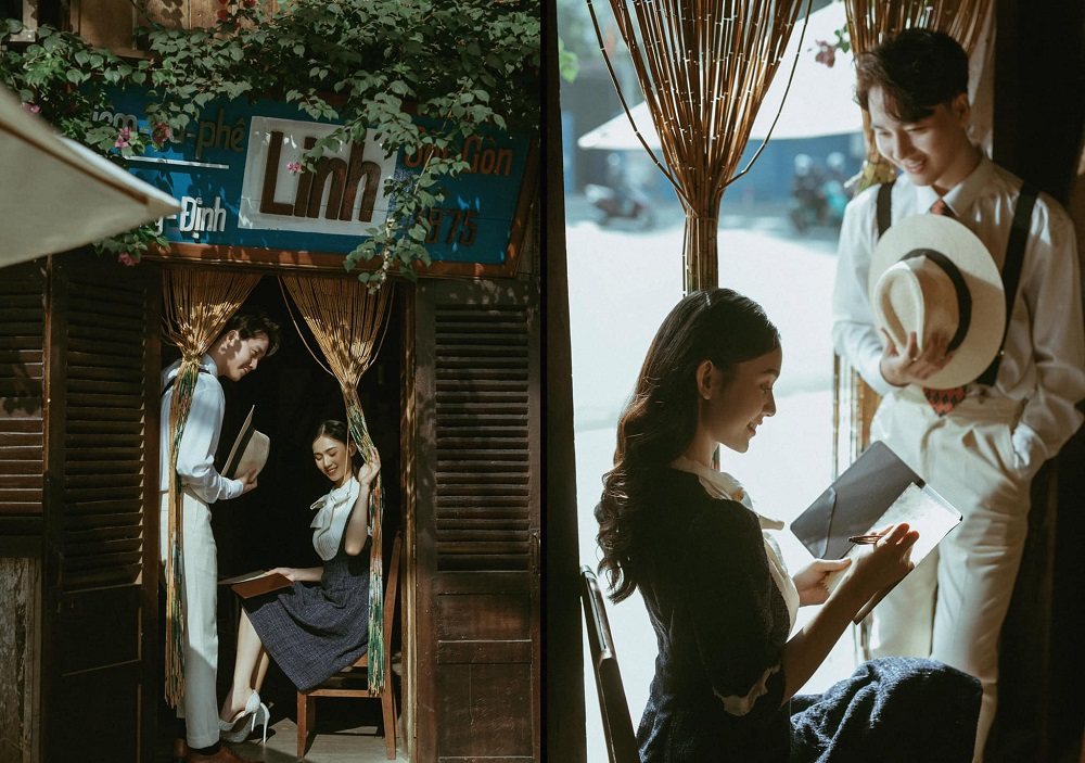 Đôi nam nữ tại quán cà phê cổ điển, người phụ nữ ngồi viết, người đàn ông cầm mũ, cùng nhau trò chuyện vui vẻ.