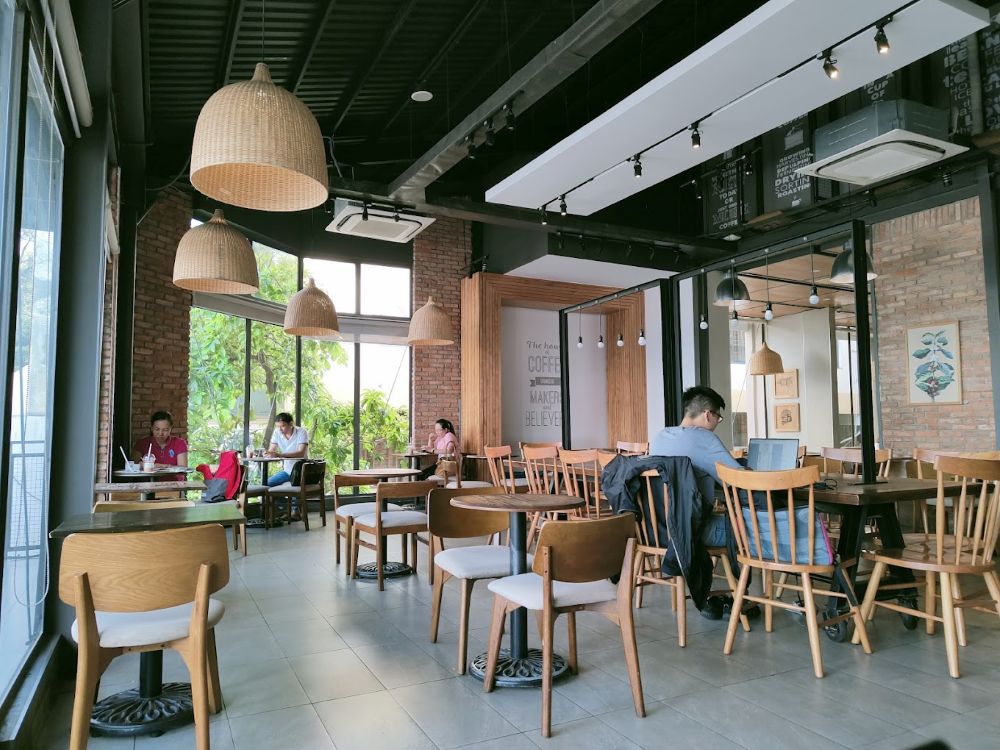 Khám Phá Top 10 Quán Cà Phê Yên Tĩnh Quận 3 Lý Tưởng Cho "Chạy Deadline" 24 Quán cà phê với nội thất gỗ, ánh sáng tự nhiên và khách hàng ngồi làm việc, trò chuyện.