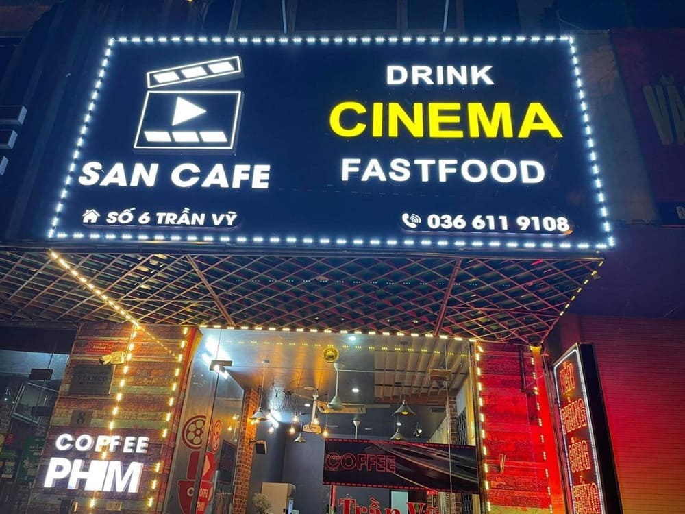 Top 9 Quán Cafe Phim Cầu Giấy Đáng Thử: Thưởng Thức Phim Hay, Cà Phê Ngon 7 Biển hiệu quán cà phê có chữ "Cinema," "Fastfood" và địa chỉ, số điện thoại. Quán trang trí đèn sáng.
