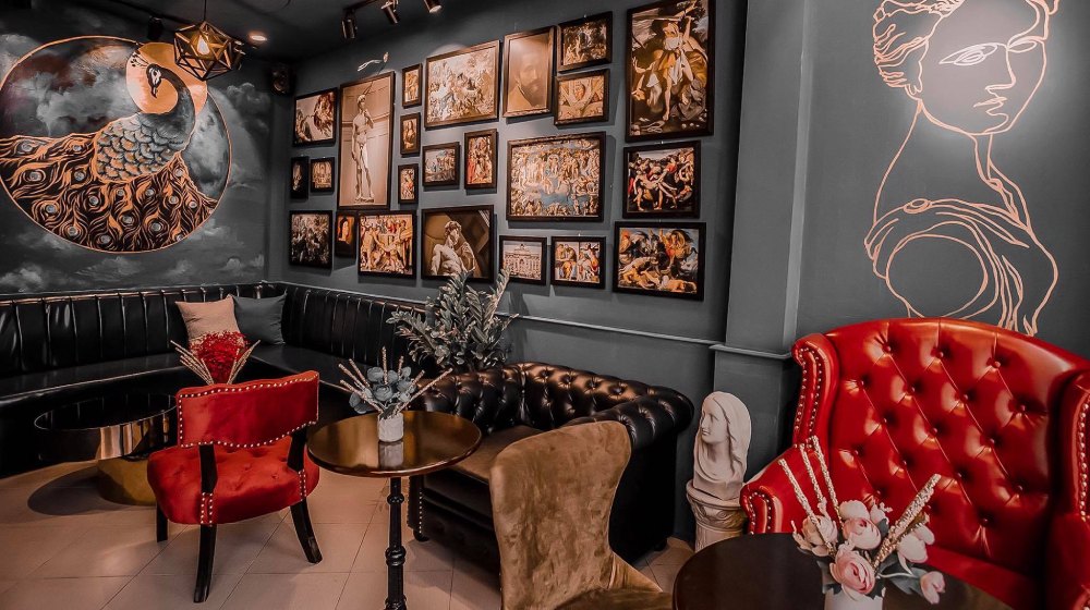 Phòng khách sang trọng với tranh tường công và đồ nội thất cổ điển, tạo không gian nghệ thuật độc đáo.