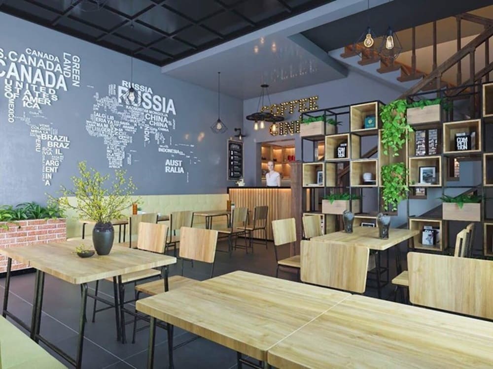 Top 9 Quán Cafe Phim Cầu Giấy Đáng Thử: Thưởng Thức Phim Hay, Cà Phê Ngon 18 Quán cà phê với bàn ghế gỗ, tường trang trí bản đồ thế giới, kệ sách và cây xanh trang trí.