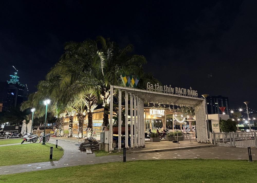 Khám Phá Những Quán Cafe View Sông Sài Gòn Đẹp Nhất Không Thể Bỏ Lỡ 7 Lối vào ga tàu thủy Bạch Đằng ban đêm, có cây cọ và ánh sáng đèn, không khí yên tĩnh.