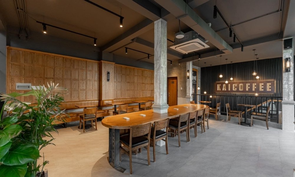 Khám Phá 15 Quán Cafe Yên Tĩnh ở Quận 1: Không Gian Thoải Mái, Thức Uống Tuyệt Hảo 5 Quán cà phê với bàn ghế gỗ, cây xanh và biển hiệu, không gian ấm cúng và ánh sáng đèn trang trí.