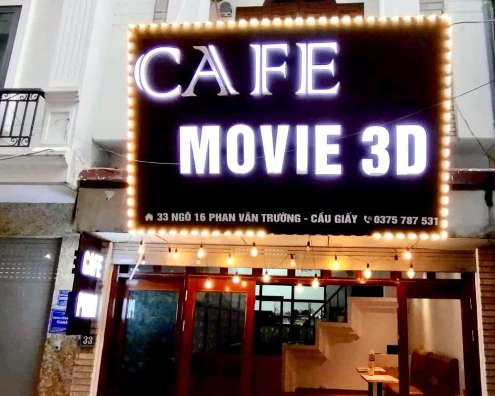Top 9 Quán Cafe Phim Cầu Giấy Đáng Thử: Thưởng Thức Phim Hay, Cà Phê Ngon 9 Biển hiệu quán cà phê chiếu phim 3D, địa chỉ và số điện thoại hiển thị rõ ràng trên nền đèn sáng.
