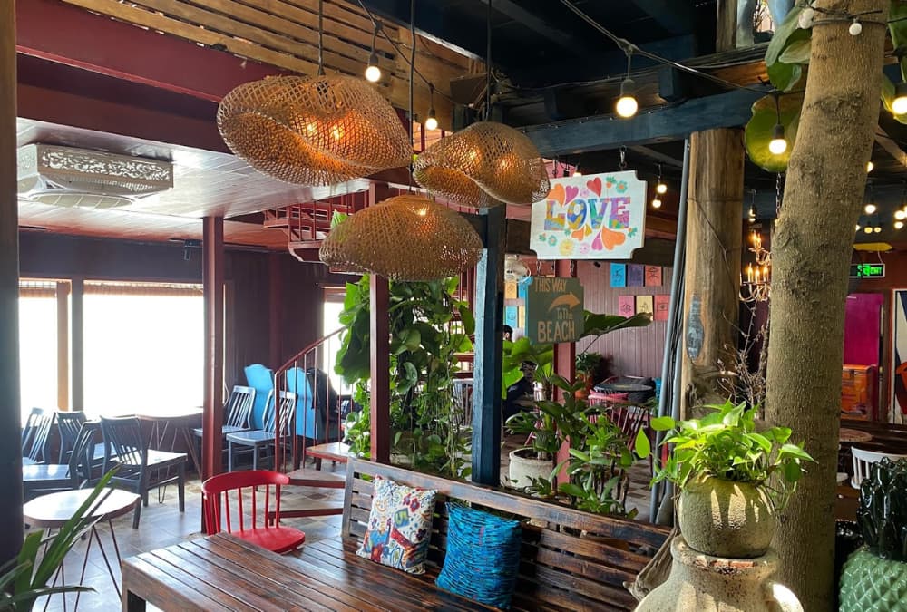 Khám Phá 12+ Quán Cafe Ngắm Hoàng Hôn Tuyệt Đẹp Tại Vũng Tàu 10 Quán cà phê ấm cúng với nội thất gỗ, đèn trang trí và cây xanh, tạo không gian thư giãn và thoải mái.