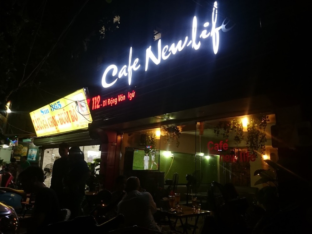 Quán Café New Life tại đường Đặng Văn Ngữ, ánh sáng mờ và không gian bên ngoài buổi tối.