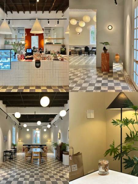 Qu&aacute;n c&agrave; ph&ecirc; hiện đại với thiết kế tối giản, gồm quầy pha chế, b&agrave;n ghế, đ&egrave;n treo v&agrave; c&acirc;y xanh trang tr&iacute;.