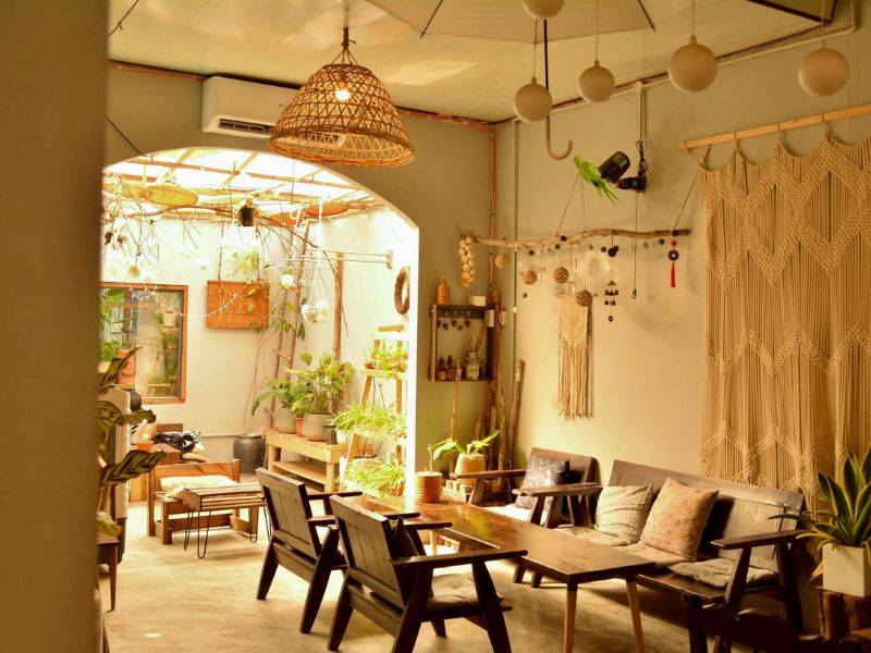 Qu&aacute;n c&agrave; ph&ecirc; ấm c&uacute;ng với nội thất gỗ, c&acirc;y xanh v&agrave; đ&egrave;n trang tr&iacute;, tạo kh&ocirc;ng gian thư gi&atilde;n v&agrave; gần gũi.