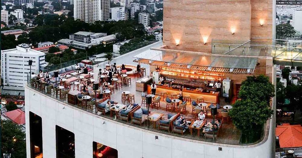 Qu&aacute;n bar tr&ecirc;n s&acirc;n thượng với kh&aacute;ch ngồi thưởng thức đồ uống v&agrave; ngắm cảnh th&agrave;nh phố từ tr&ecirc;n cao.