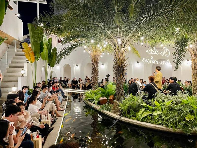 Qu&aacute;n c&agrave; ph&ecirc; với nhiều c&acirc;y xanh v&agrave; ao nhỏ, đ&ocirc;ng người ngồi thư gi&atilde;n v&agrave; tr&ograve; chuyện v&agrave;o buổi tối.