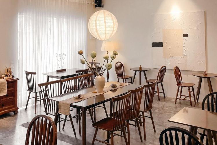 Qu&aacute;n c&agrave; ph&ecirc; với b&agrave;n ghế gỗ, trang tr&iacute; đơn giản, đ&egrave;n lồng treo v&agrave; tranh tường hiện đại.