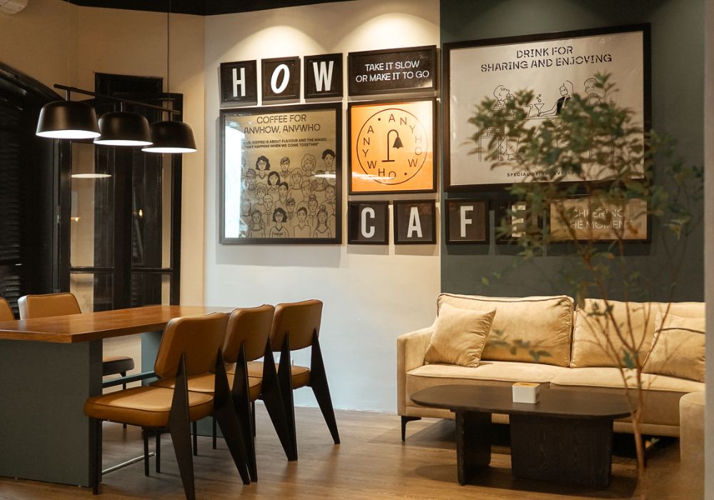 Khám Phá Top 10 Quán Cafe Láng Hạ: View Đẹp, Menu Hấp Dẫn, Giá Cực Hợp Lý 11 Quán cà phê với bàn ghế gỗ, ghế sofa và tranh treo tường trang trí, không gian ấm cúng và ánh sáng dịu nhẹ.