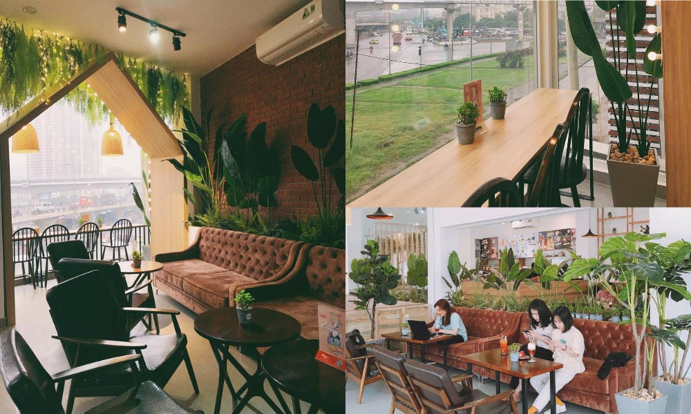 Qu&aacute;n c&agrave; ph&ecirc; với nội thất ấm c&uacute;ng, b&agrave;n ghế gỗ, c&acirc;y xanh trang tr&iacute;, v&agrave; cửa sổ lớn nh&igrave;n ra ngo&agrave;i.