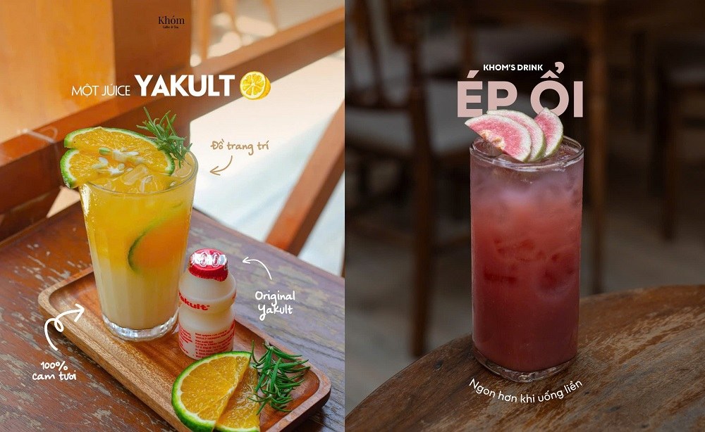 Khám Phá 12+ Quán Cafe Đẹp Hút Triệu View Tại TPHCM Năm 2025 9 Hai ly nước trái cây trên bàn gỗ: một ly cam Yakult và một ly ép ổi, trang trí với lát cam và ổi.