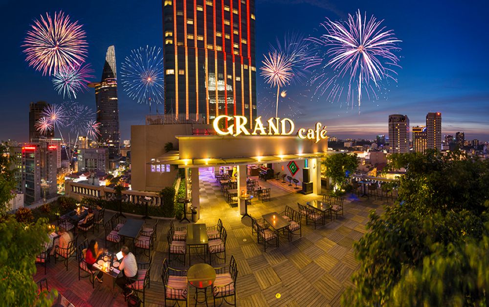 Khám Phá Top 10 Quán Rooftop Quận 1: View Đẹp Ngắm Thành Phố, Trải Nghiệm Thư Giãn Tuyệt Đỉnh 11 Quán cà phê sân thượng tại thành phố lớn với pháo hoa rực rỡ trên bầu trời đêm, tạo không gian lãng mạn.