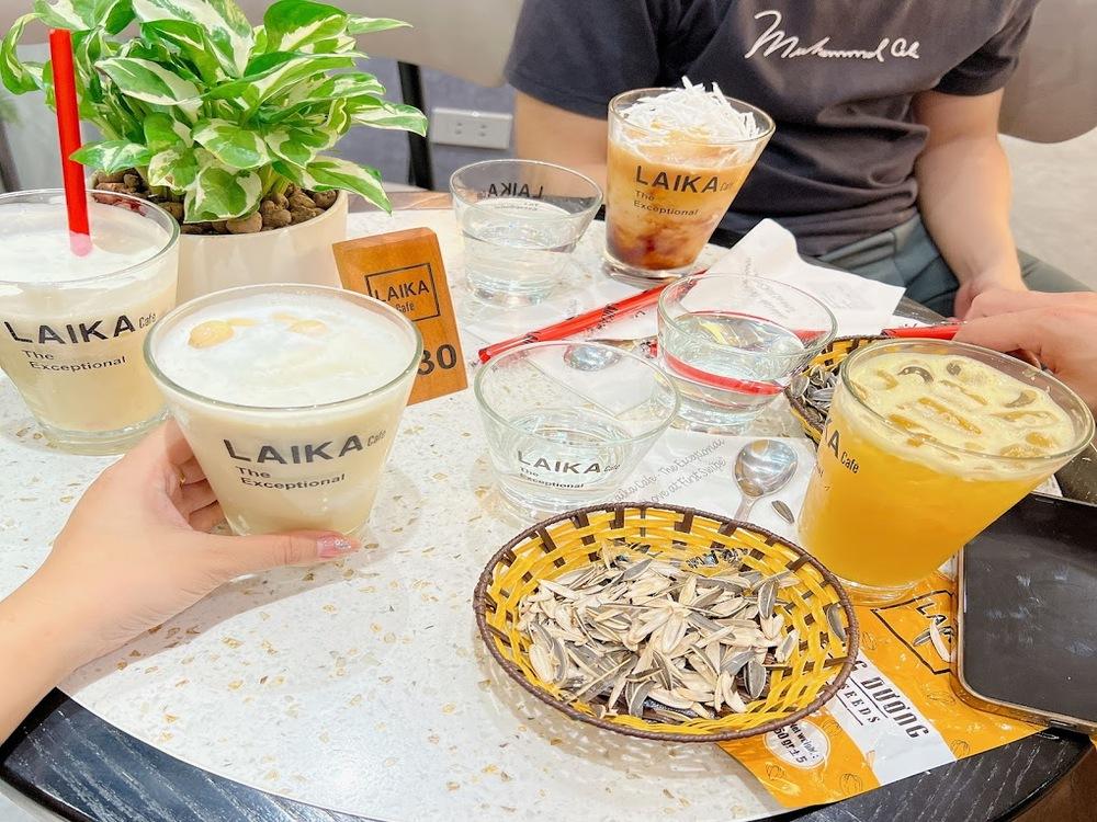 Khám Phá Top 10 Quán Cafe Giảng Võ Hấp Dẫn Nhất Tại Hà Nội 10 Bàn cafe với nhiều loại đồ uống, đĩa hạt hướng dương và cây xanh trang trí trên bàn.