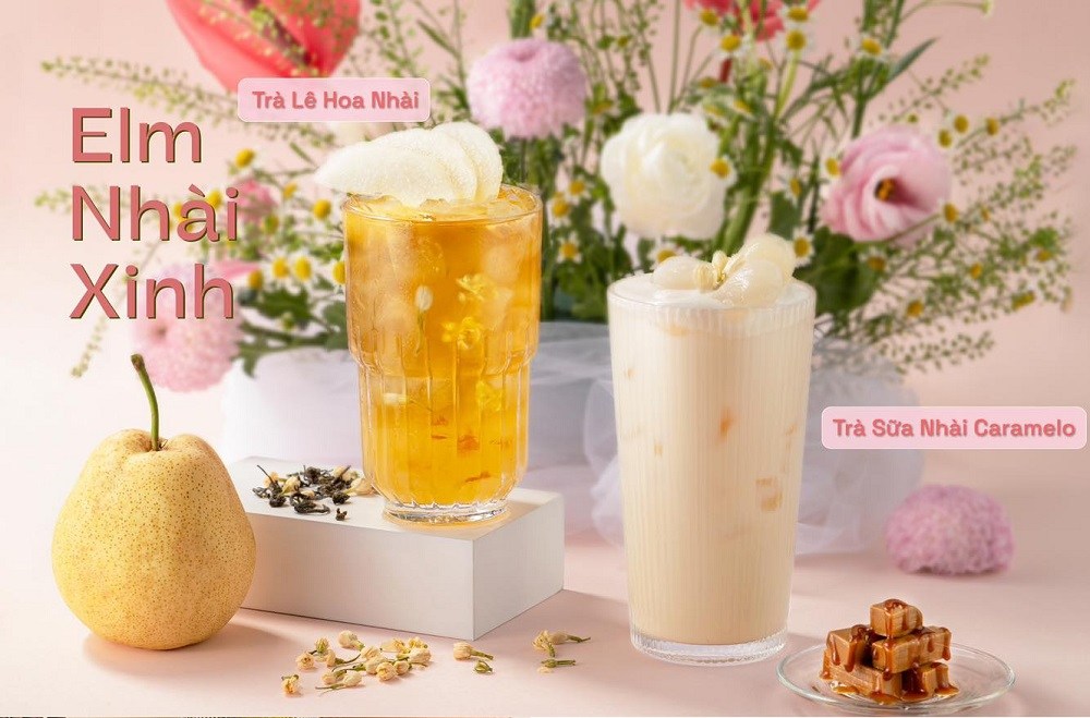 Khám Phá Những Quán Cafe Độc Lạ Thu Hút Giới Trẻ Tại Sài Gòn 5 Hai ly trà với hoa nhài, một ly màu vàng, một ly màu trắng, đặt cạnh quả lê và caramel, nền hoa.