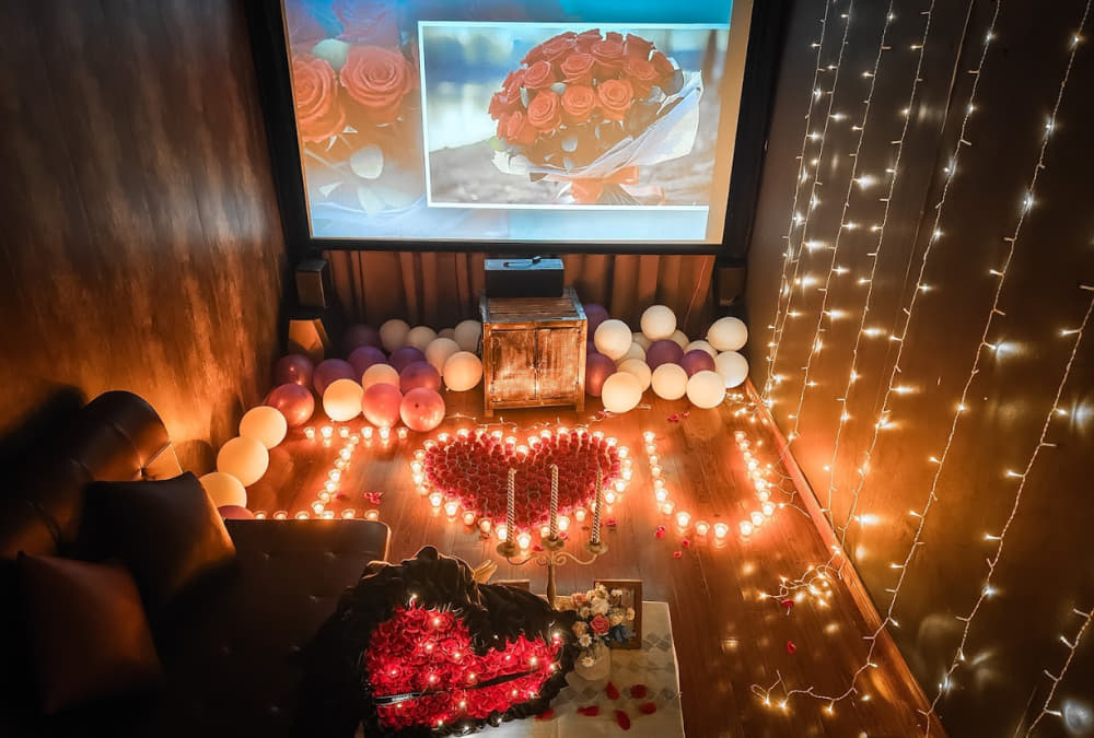 Trải Nghiệm Cafe Phim Lãng Mạn Tại Chùa Láng Cùng Người Thương 4 Phòng trang trí với bóng bay, nến và hoa hồng, màn chiếu hình bó hoa, tạo không gian lãng mạn và ấm áp.