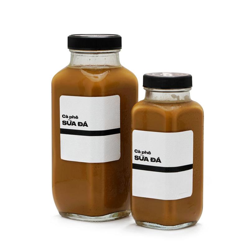 cach-pha-ca-phe-dong-chai-7 Hai chai cà phê sữa đá với nắp đen và nhãn trắng, một chai lớn và một chai nhỏ.