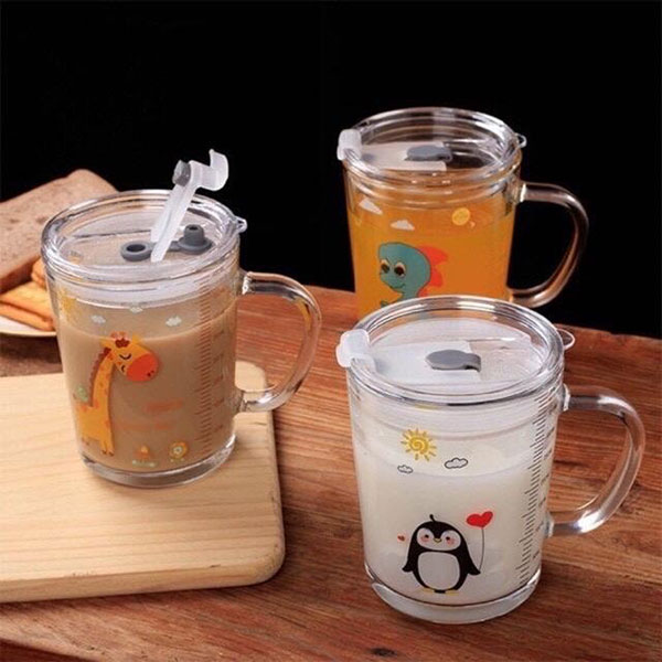 Ba cốc thủy tinh có nắp, chứa các loại đồ uống, in hình động vật dễ thương, đặt trên mặt bàn gỗ.