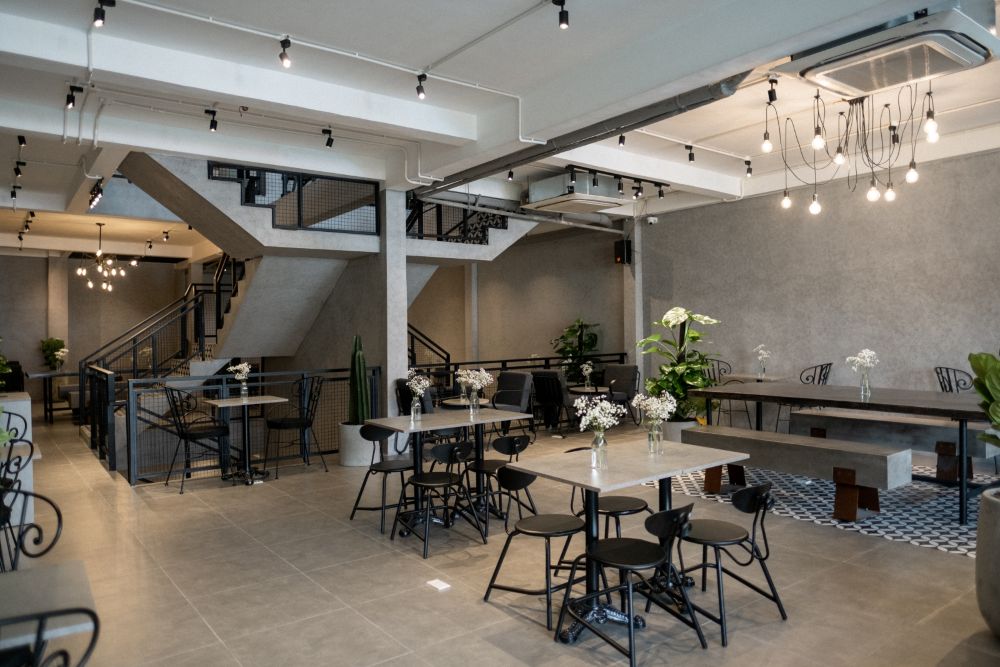 Khám Phá 4 Quán Cafe 24h Ở Bình Thạnh Hoàn Hảo Cho Làm Việc Và Thư Giãn 4 Quán cà phê hiện đại với bàn ghế kim loại và cây xanh trang trí, không gian thoáng đãng và ánh sáng dịu nhẹ.
