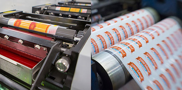 Máy in công nghiệp đang in nhãn màu trên cuộn giấy, hiển thị quá trình in ấn chi tiết và sắc nét.