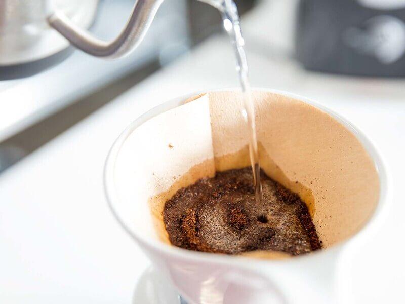 nel-drip-coffee-10 Nước đang được đổ vào phin cà phê giấy chứa bột cà phê.