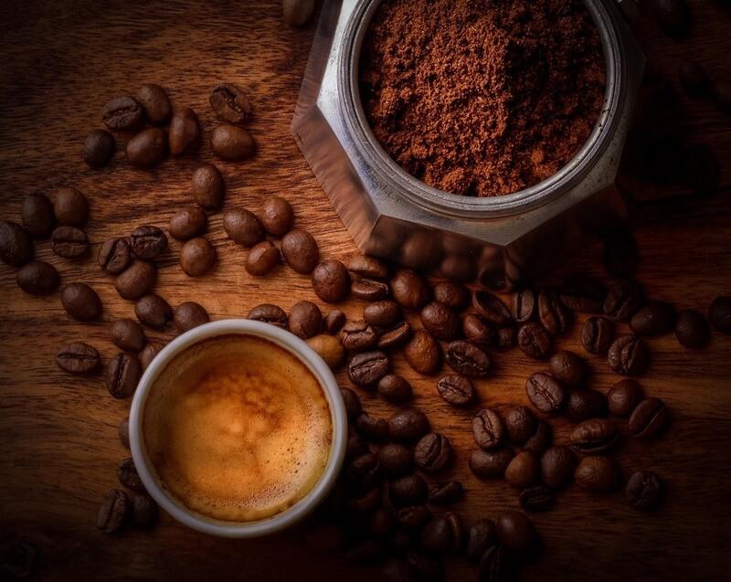nel-drip-coffee-9 Cốc cà phê espresso bên cạnh bột cà phê và hạt cà phê trên bàn gỗ.