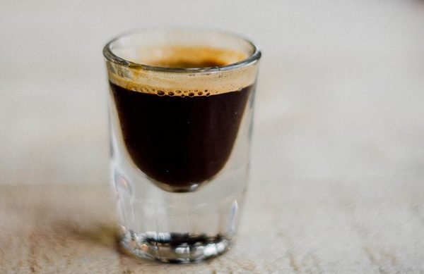 simple-espresso-600x389-1 Ly espresso nhỏ với lớp crema trên bề mặt, đặt trên nền sáng màu.