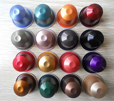 uu-nhuoc-diem-cua-ca-phe-vien-nen-capsule Các viên nén cà phê nhiều màu sắc được xếp thành hàng trên bề mặt gỗ sáng màu.