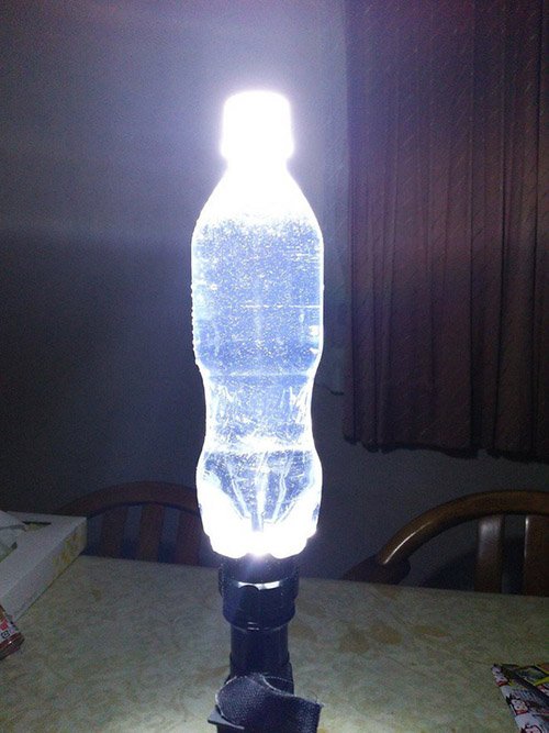 chai-nhua-de-khuych-dai-anh-sang Chai nhựa chứa nước được chiếu sáng từ dưới, tỏa sáng trong căn phòng tối.